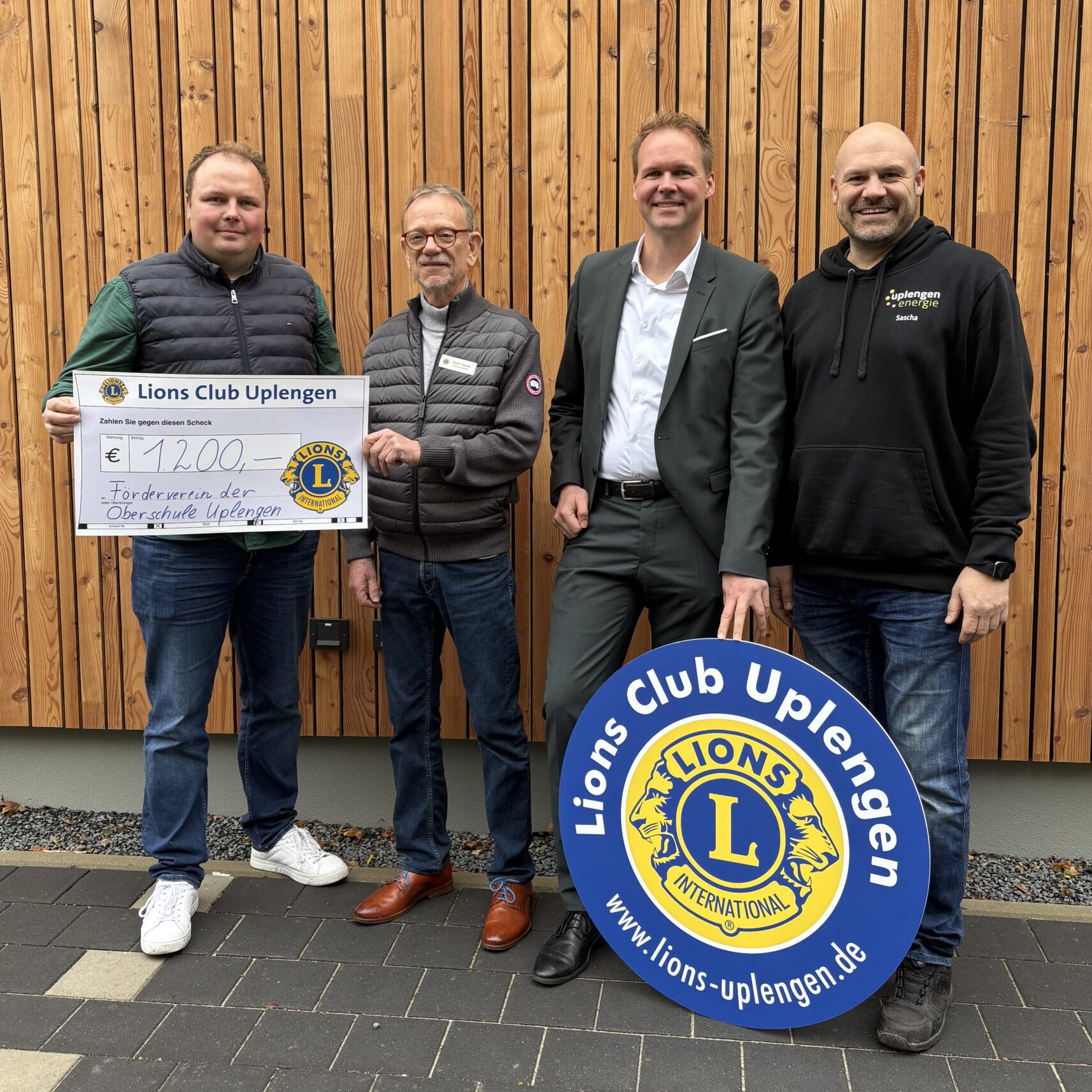 Klaas Krieger, Achim Gerdes, André Kasten und Sascha Balzen mit einem Spendenscheck über 1.200 Euro und dem Lions-Club-Schild.